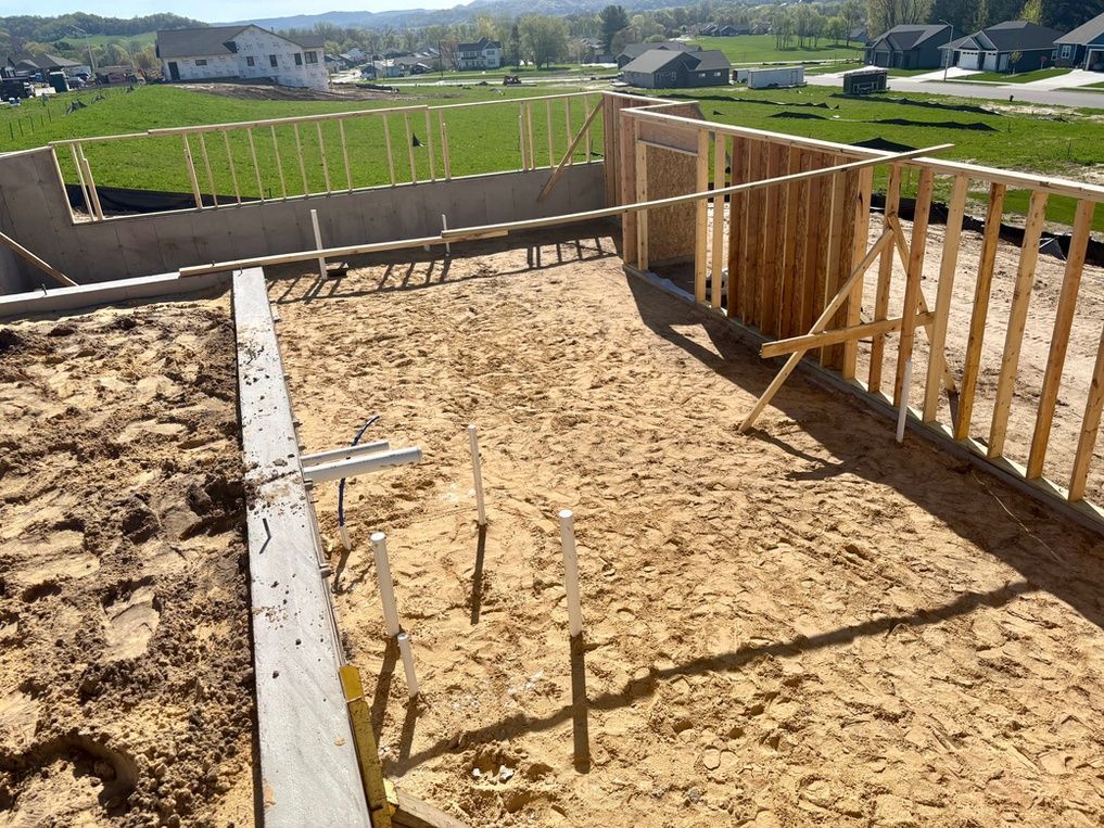 Woman in straw hat smiles, holding wine glass near a lake.