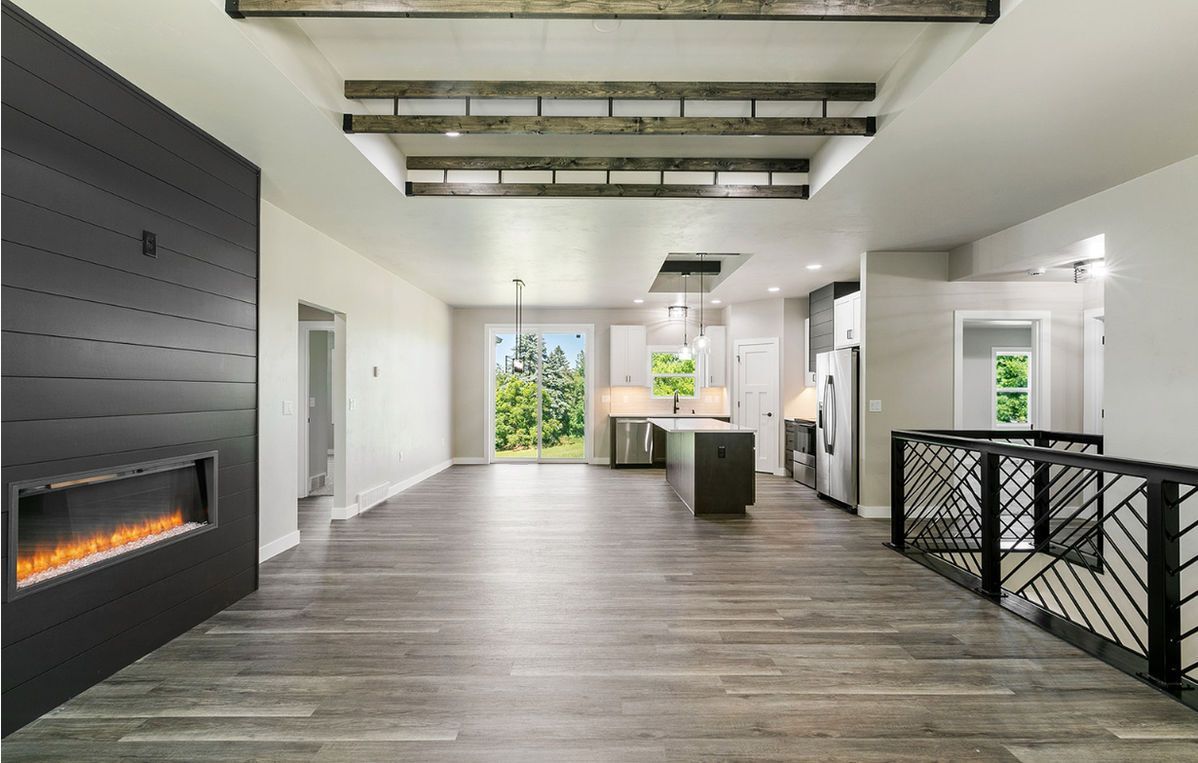 Woman in straw hat smiles, holding wine glass near a lake.