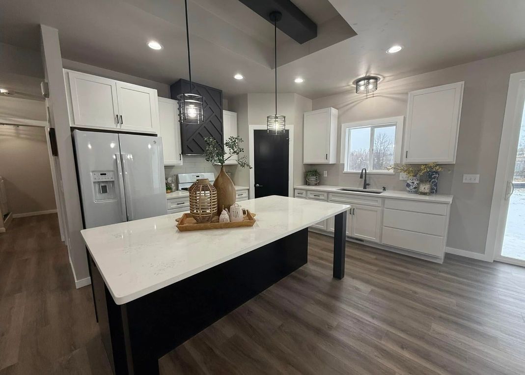 Woman in straw hat smiles, holding wine glass near a lake.