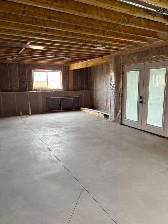 Woman in straw hat smiles, holding wine glass near a lake.