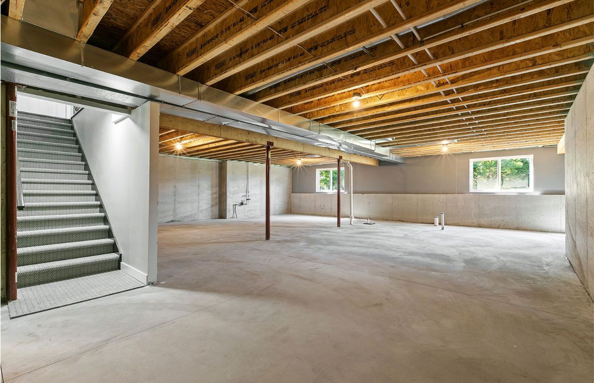 Woman in straw hat smiles, holding wine glass near a lake.