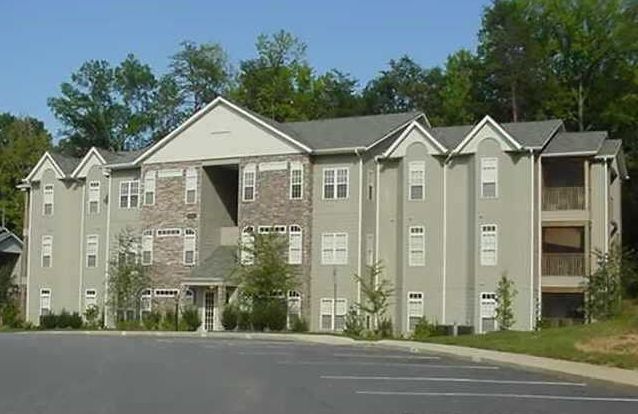 A large apartment building with a parking lot in front of it