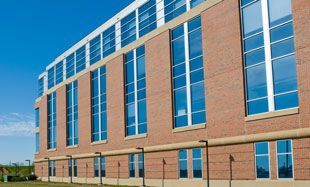 A large brick building with lots of windows on a sunny day.