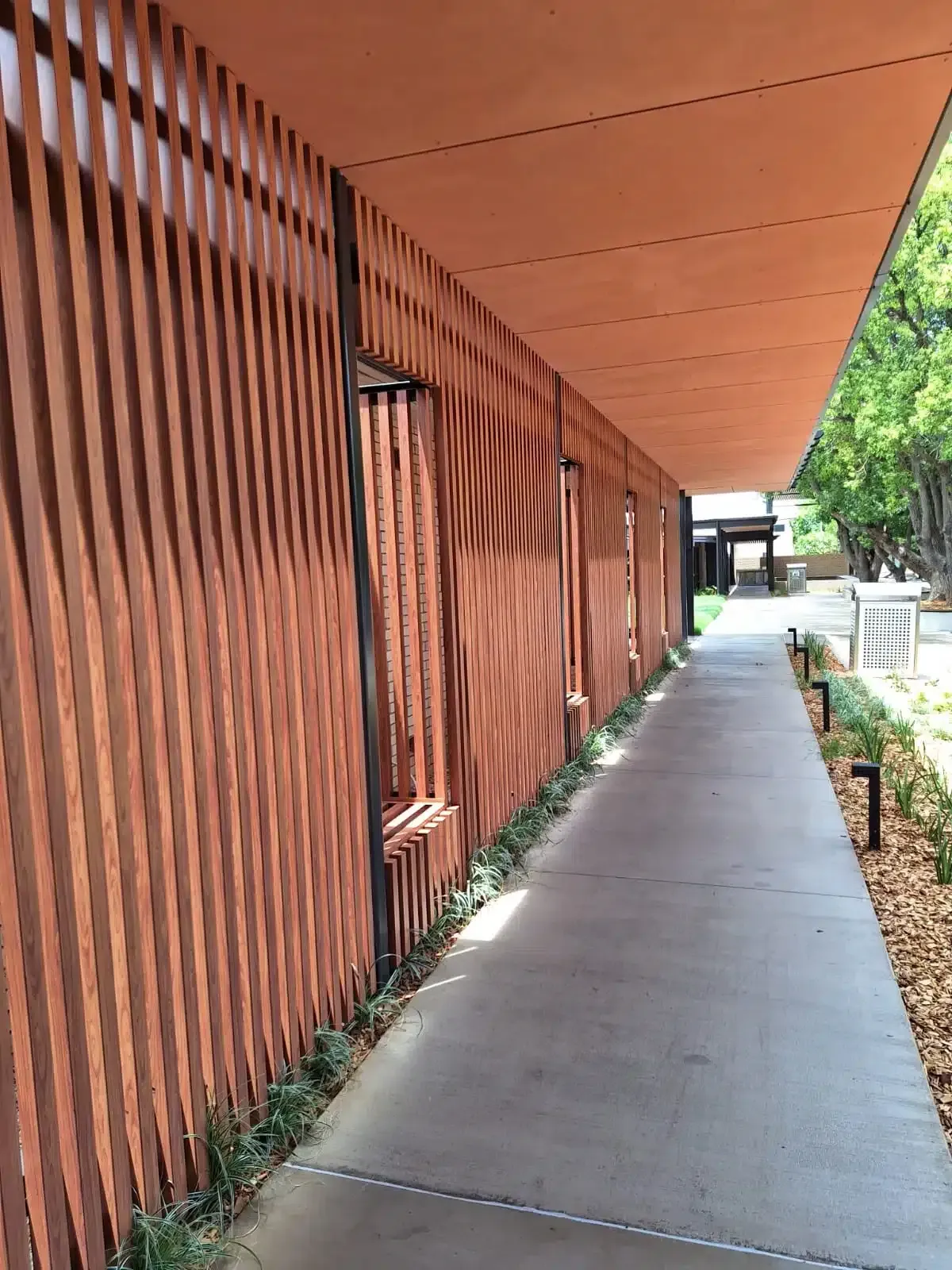 A Long Hallway With a Brick Wall and a Roof — Siash Construction Group in Woodgate, QLD
