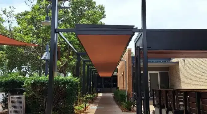 A Long Walkway Between Two Buildings With a Canopy Over It — Siash Construction Group in Gooburrum, QLD