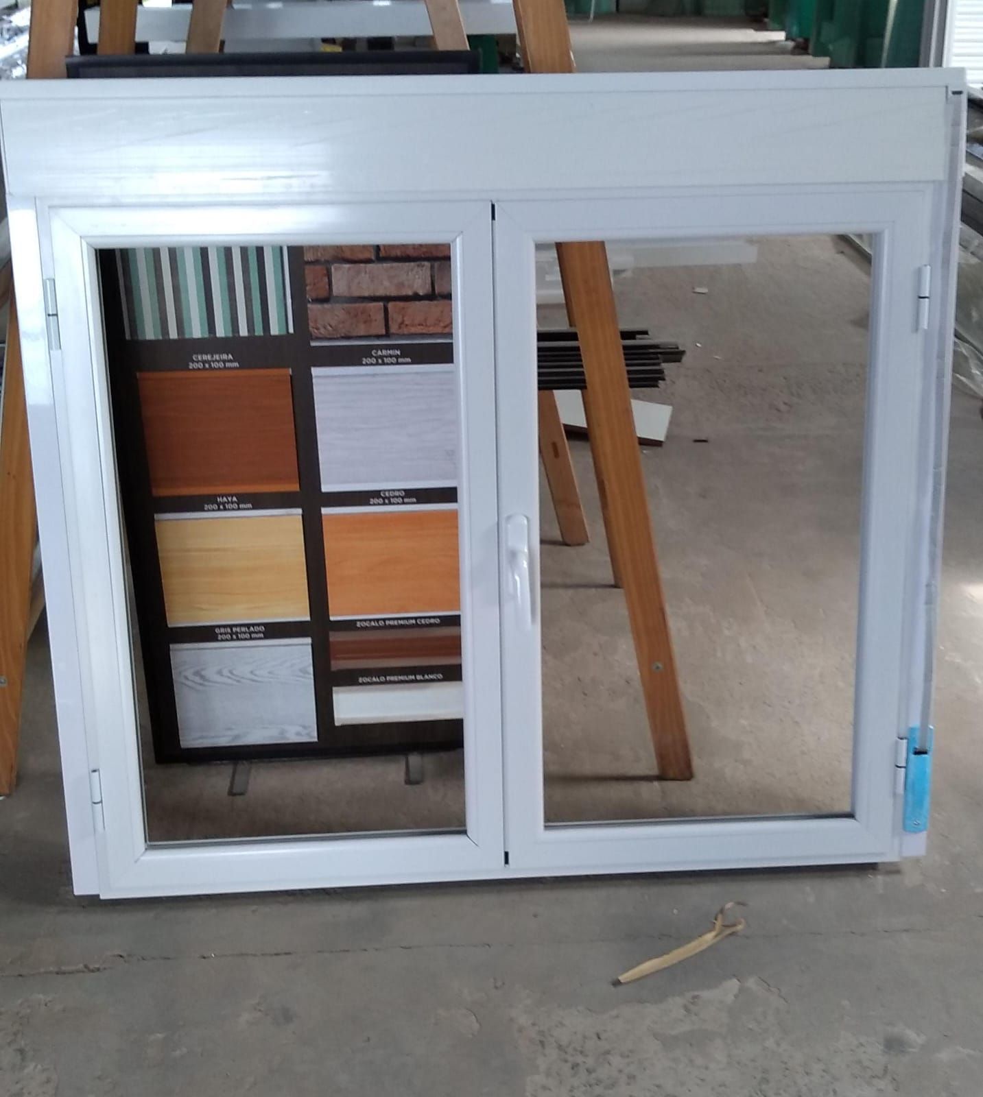 Un marco de ventana blanco de doble hoja se alza sobre el suelo