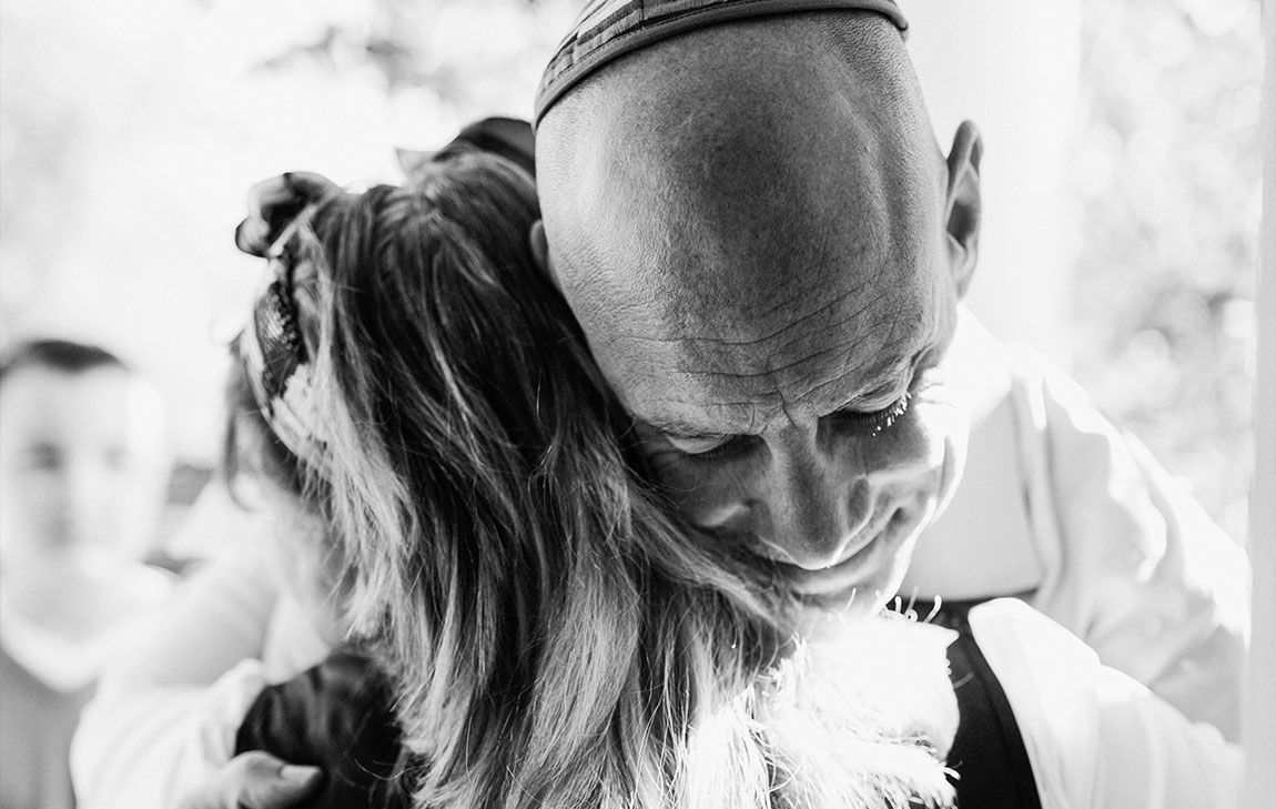 Man wearing Yarmulke, comforting a young child at a Jewish funeral