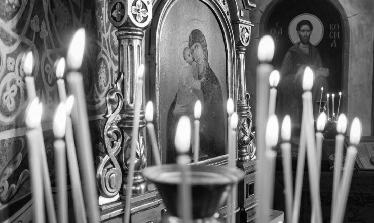 Long, thin candles lit for the departed at a Greek Orthodox funeral service