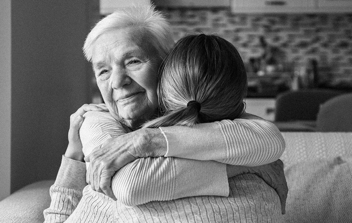 Older woman hugging younger woman to comfort  her as she is grieving