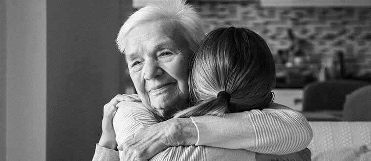 Older woman hugging younger woman to comfort her as she is grieving