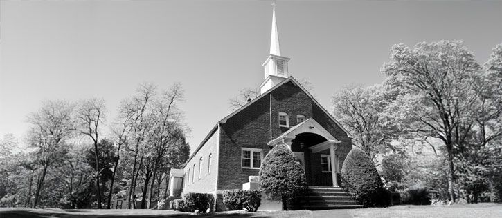 A brick Temple of The Church of Jesus Christ of Latter-day Saints with a white steeple.