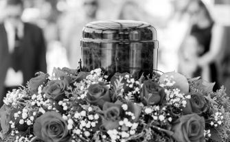 Decorative urn surrounded by flowers at a memorial service, celebrating and honoring the life and memory of a loved one.
