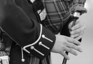 Bagpiper performing at a graveside service, reflecting personalized funeral services and meaningful memorialization options.