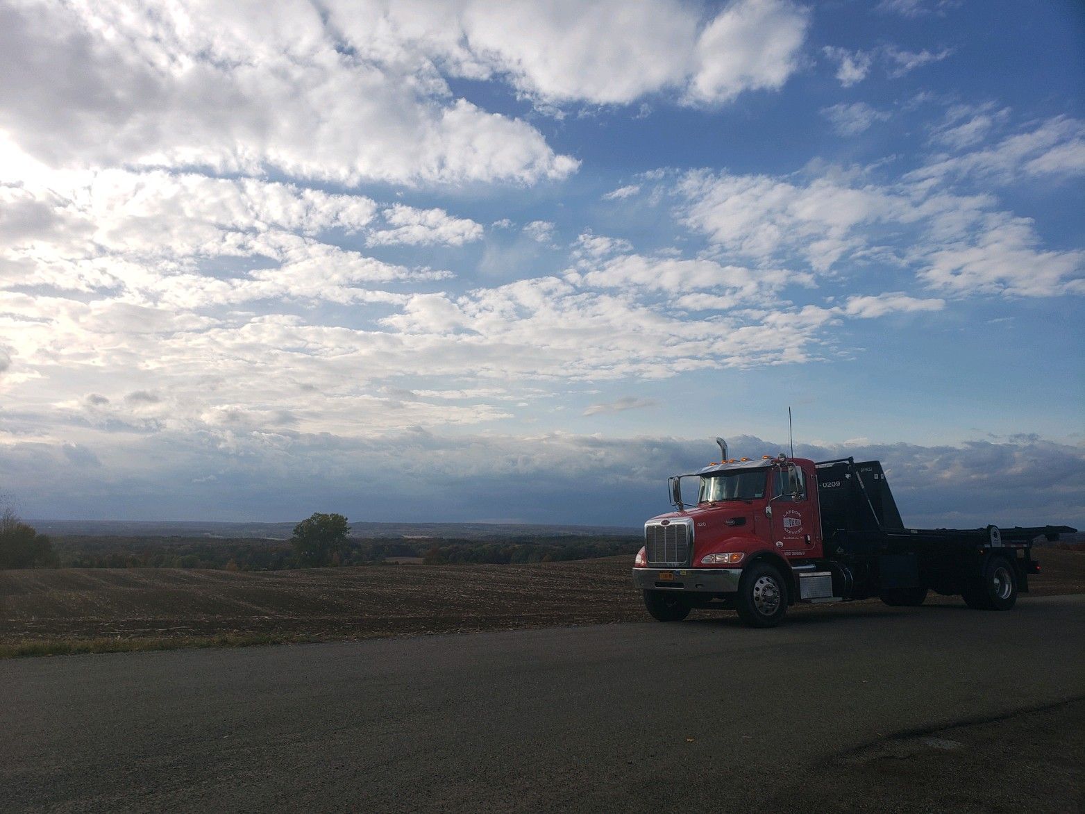 A red tow truck is parked on the side of the road.
