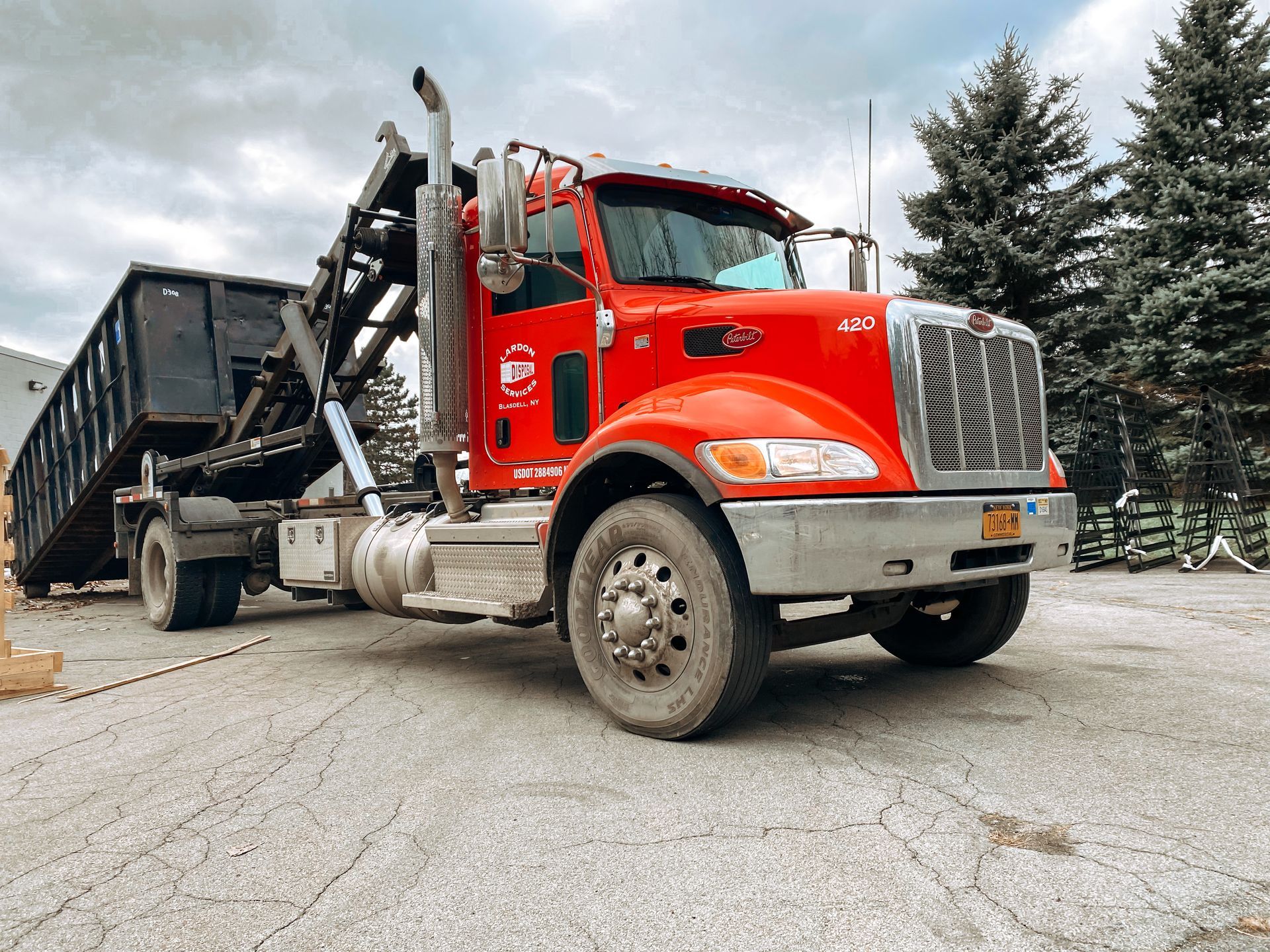 A red dump truck is parked in a parking lot.