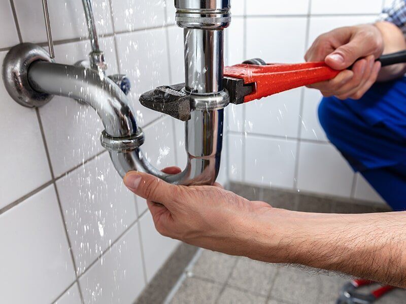 Man Inspecting A Hot Water System — Brian Cook Plumbing in Coffs Harbour, NSW