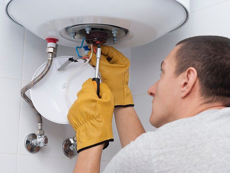 Plumber Fixing A Hot Water System — Brian Cook Plumbing in Coffs Harbour, NSW