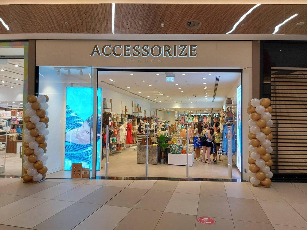 AccessoriZE store entrance with balloon decorations in a mall.
