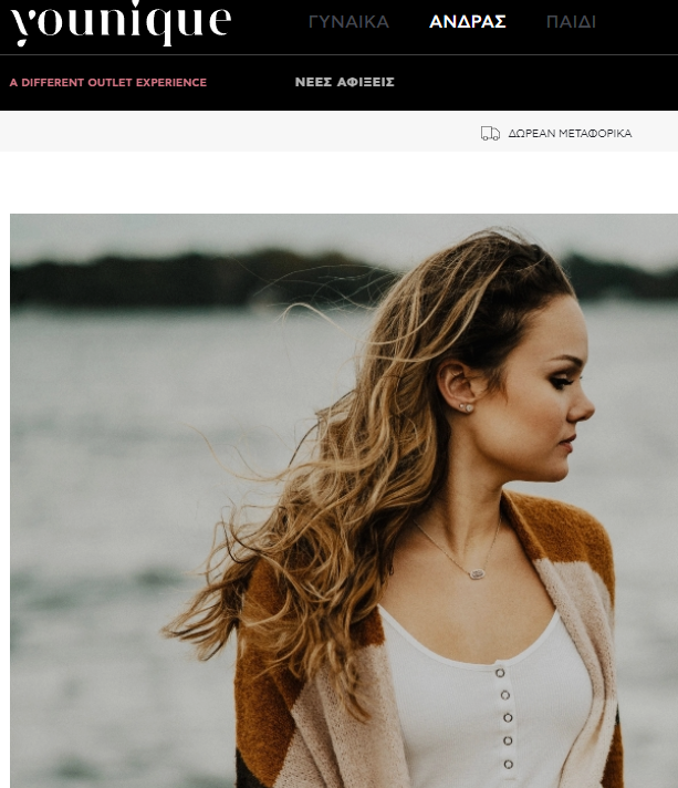 Woman with long brown hair, wearing a white top and cardigan, outdoors.