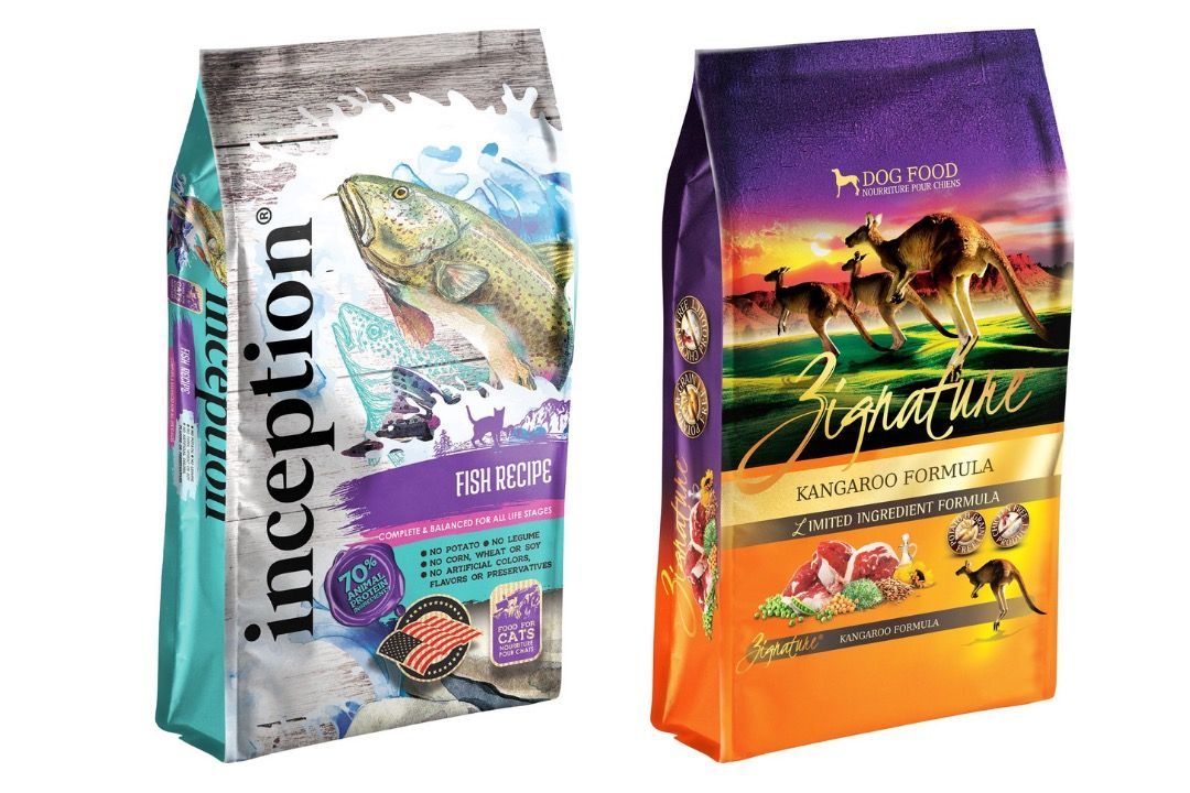 A group of dogs sitting next to bags of royal canin dog food.