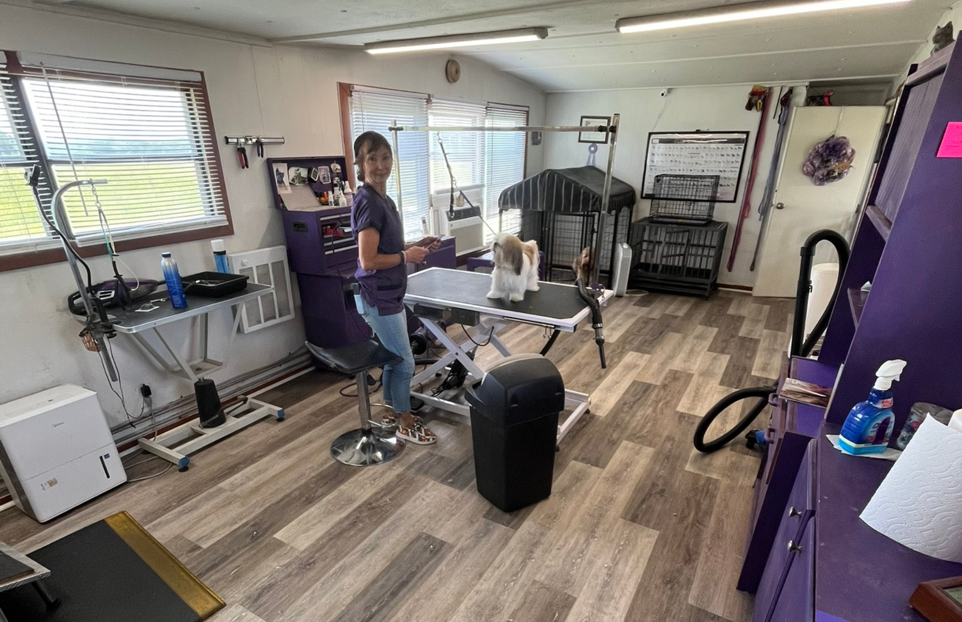 A woman is standing in a room with a vacuum cleaner.
