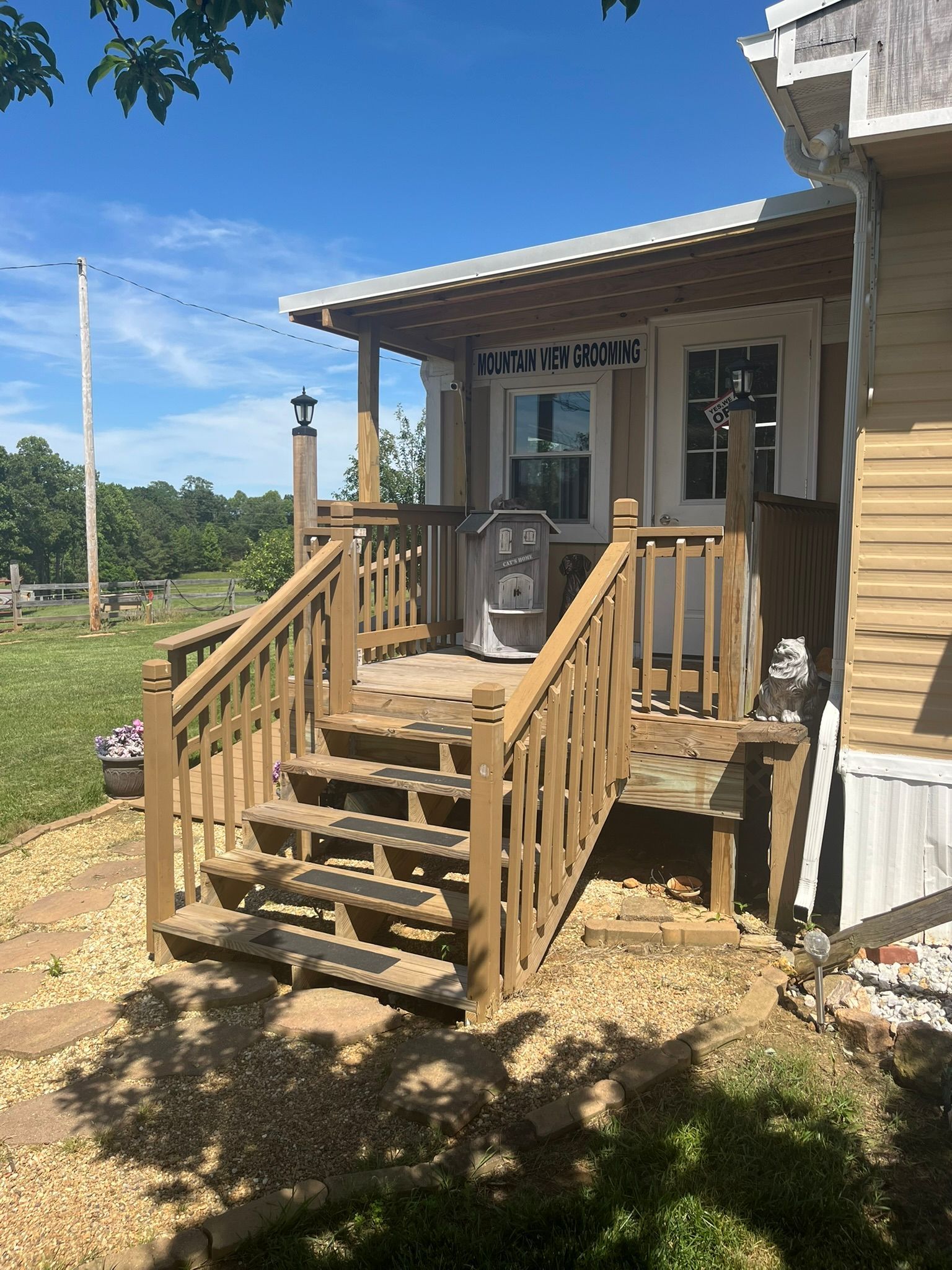 A small house with a porch and stairs leading up to it.