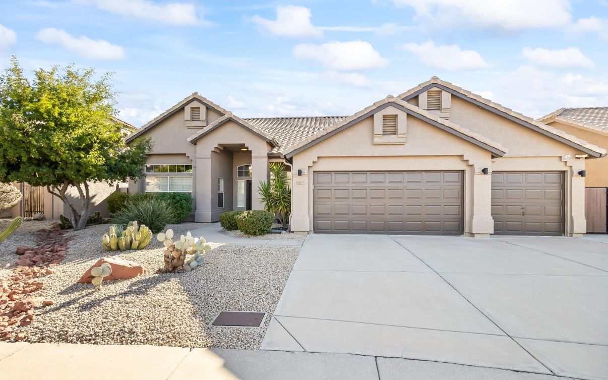 A large house with two garage doors and a driveway.