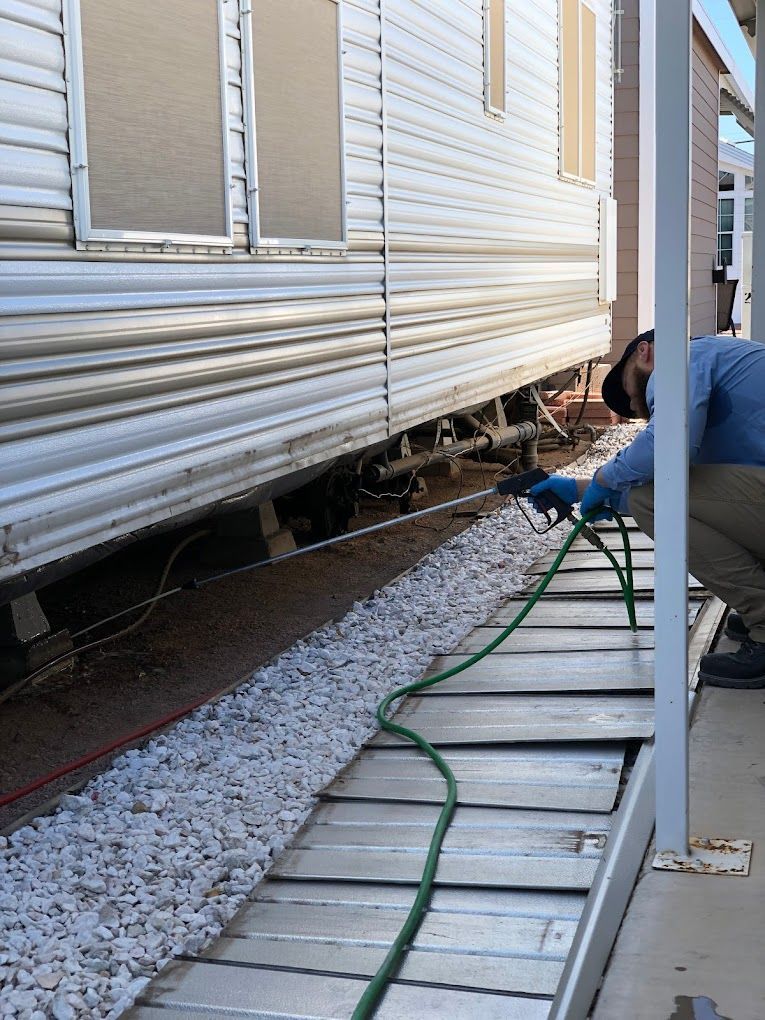 A man is spraying a trailer with a hose.