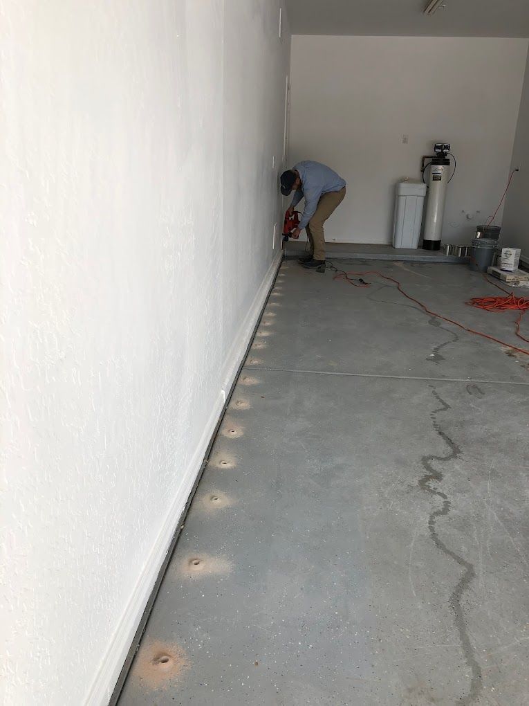 A man is working on a wall in a garage.