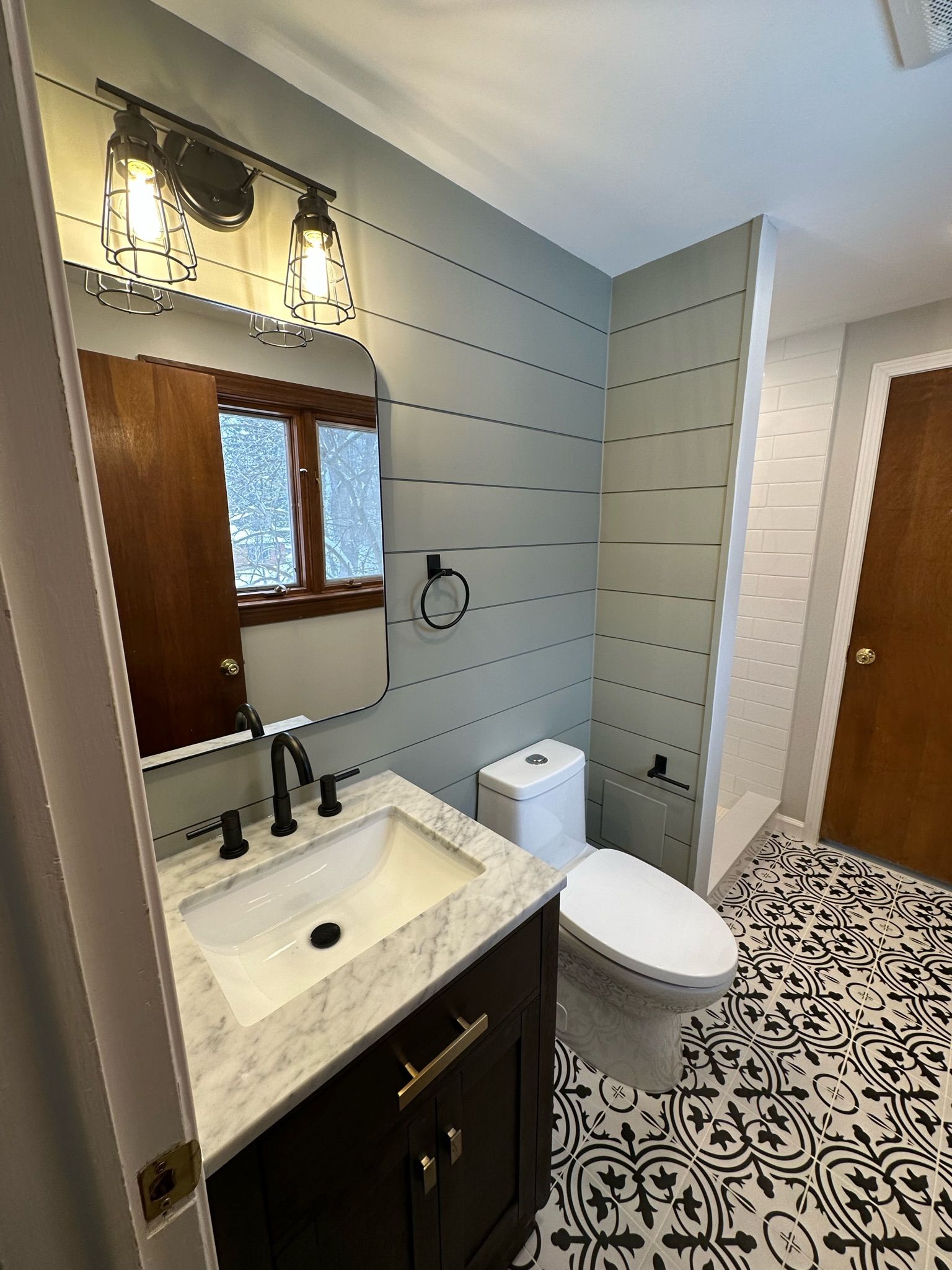 A bathroom with a toilet , sink and mirror