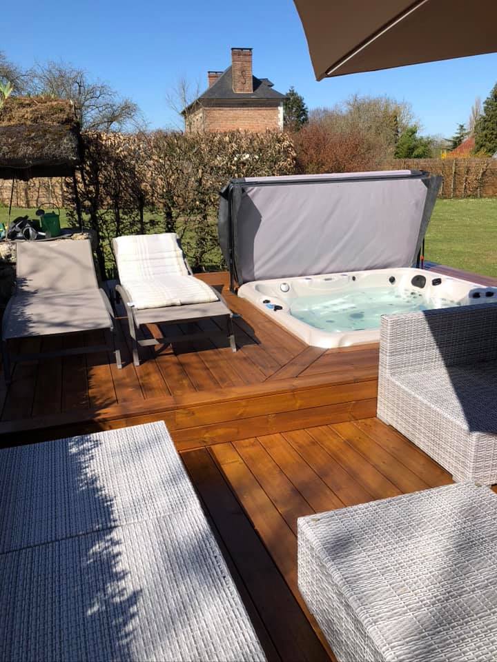 Un bain à remous est posé sur une terrasse en bois.
