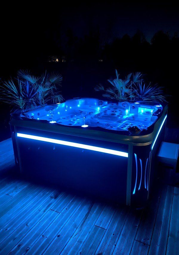 Un bain à remous est éclairé par des lumières bleues la nuit.