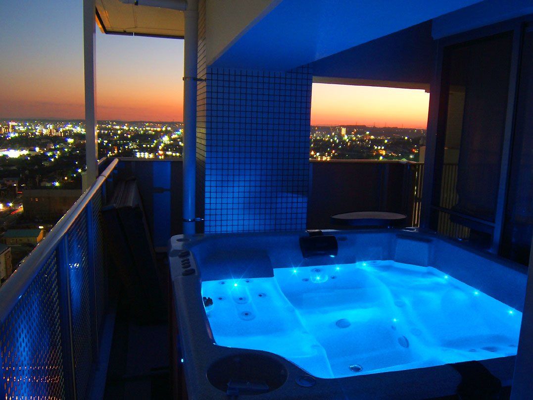 Un balcon avec un jacuzzi éclairé de lumières bleues