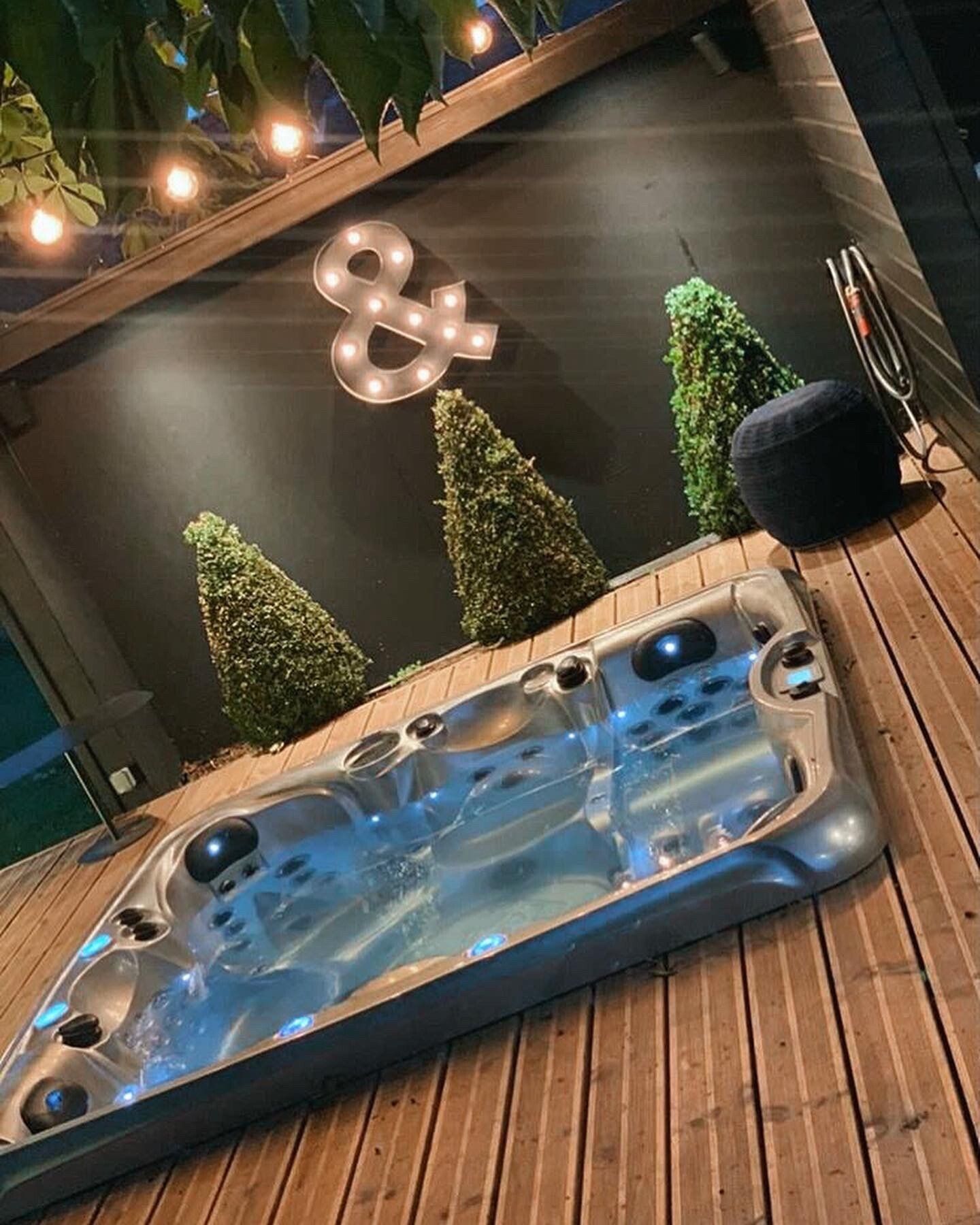 Un bain à remous est posé sur une terrasse en bois.