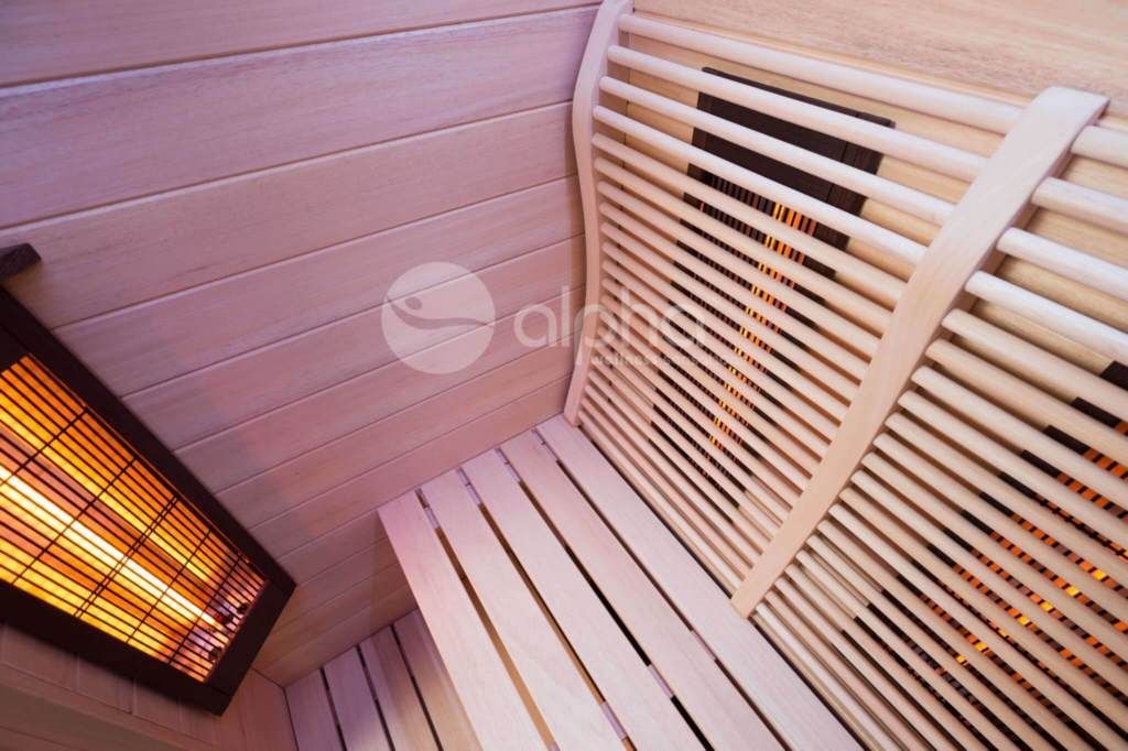 Un sauna en bois avec un poêle au mur.