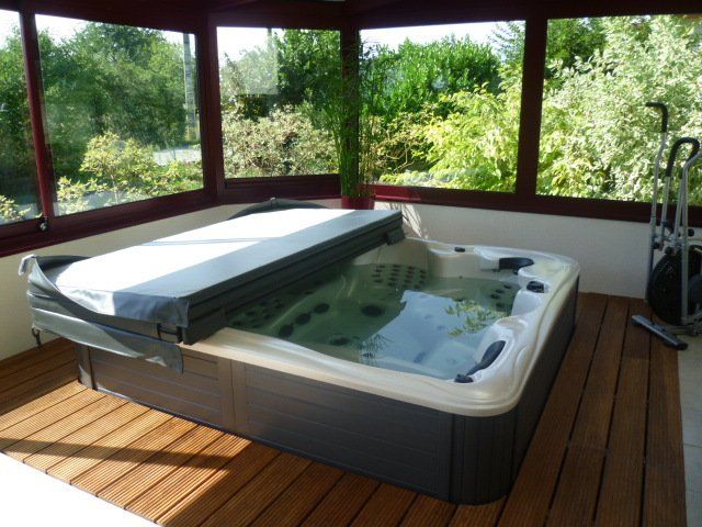 Un bain à remous dans une pièce avec beaucoup de fenêtres