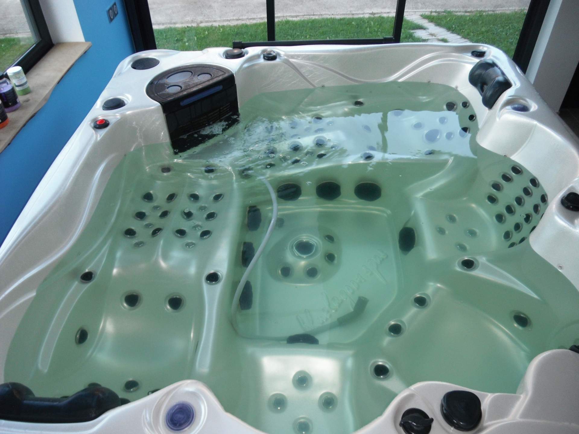 Un grand bain à remous est rempli d'eau verte