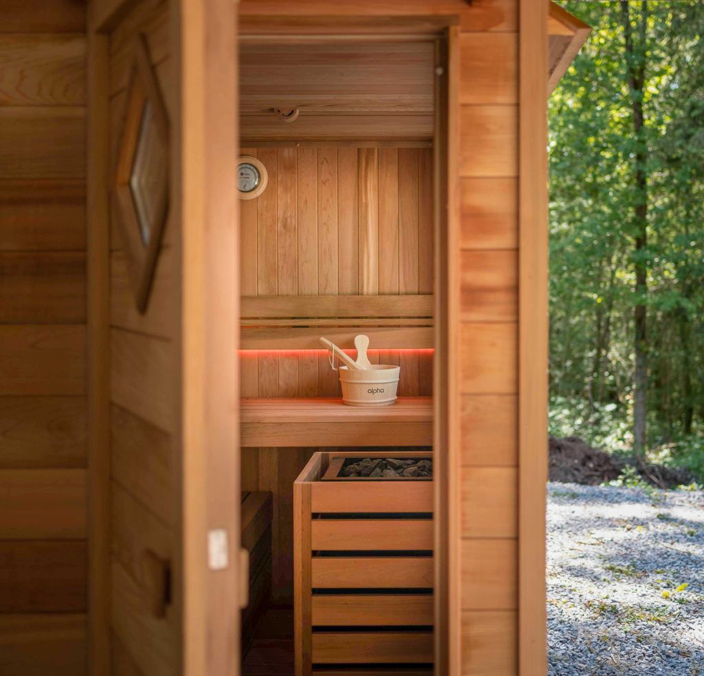 Un sauna en bois dans les bois avec un seau.