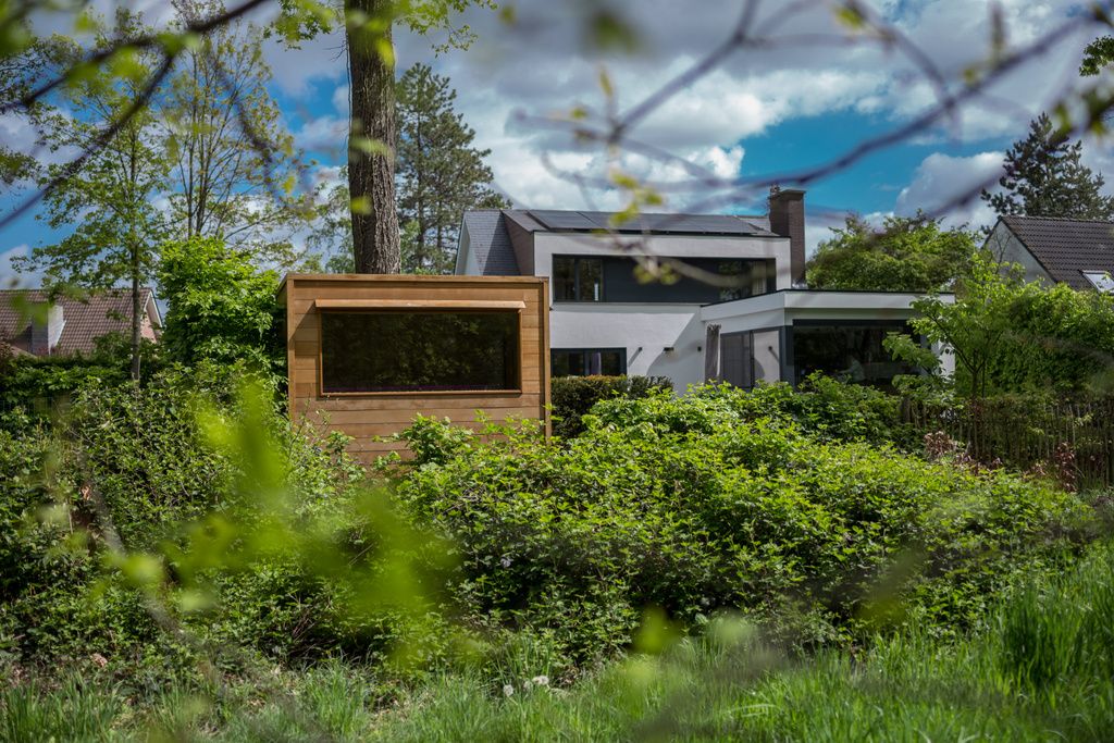 Une sauna est située au milieu d'un champ verdoyant entouré d'arbres.