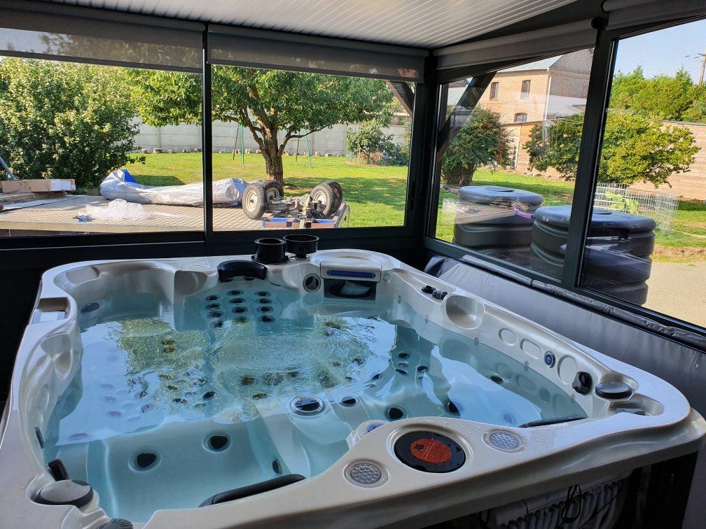 Un bain à remous est installé dans une pièce à côté d'une fenêtre.