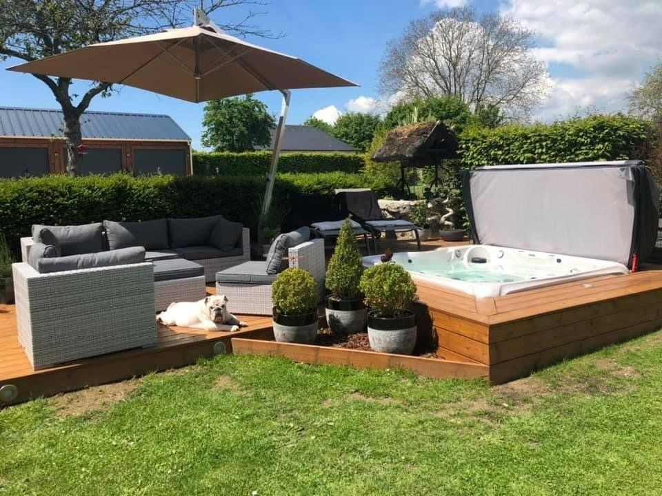 Un bain à remous est posé sur une terrasse en bois dans une cour arrière.