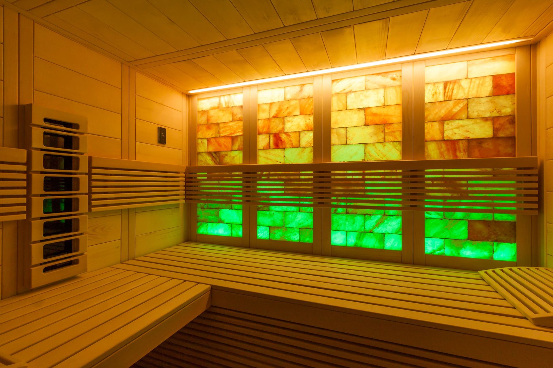 Un sauna avec beaucoup de fenêtres et de lumières sur le mur.