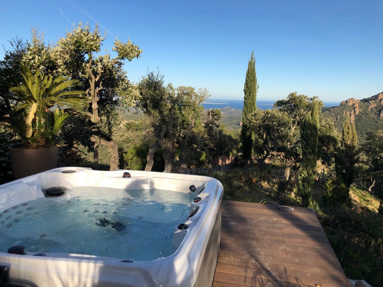 Un jacuzzi avec vue sur l'océan et les montagnes.