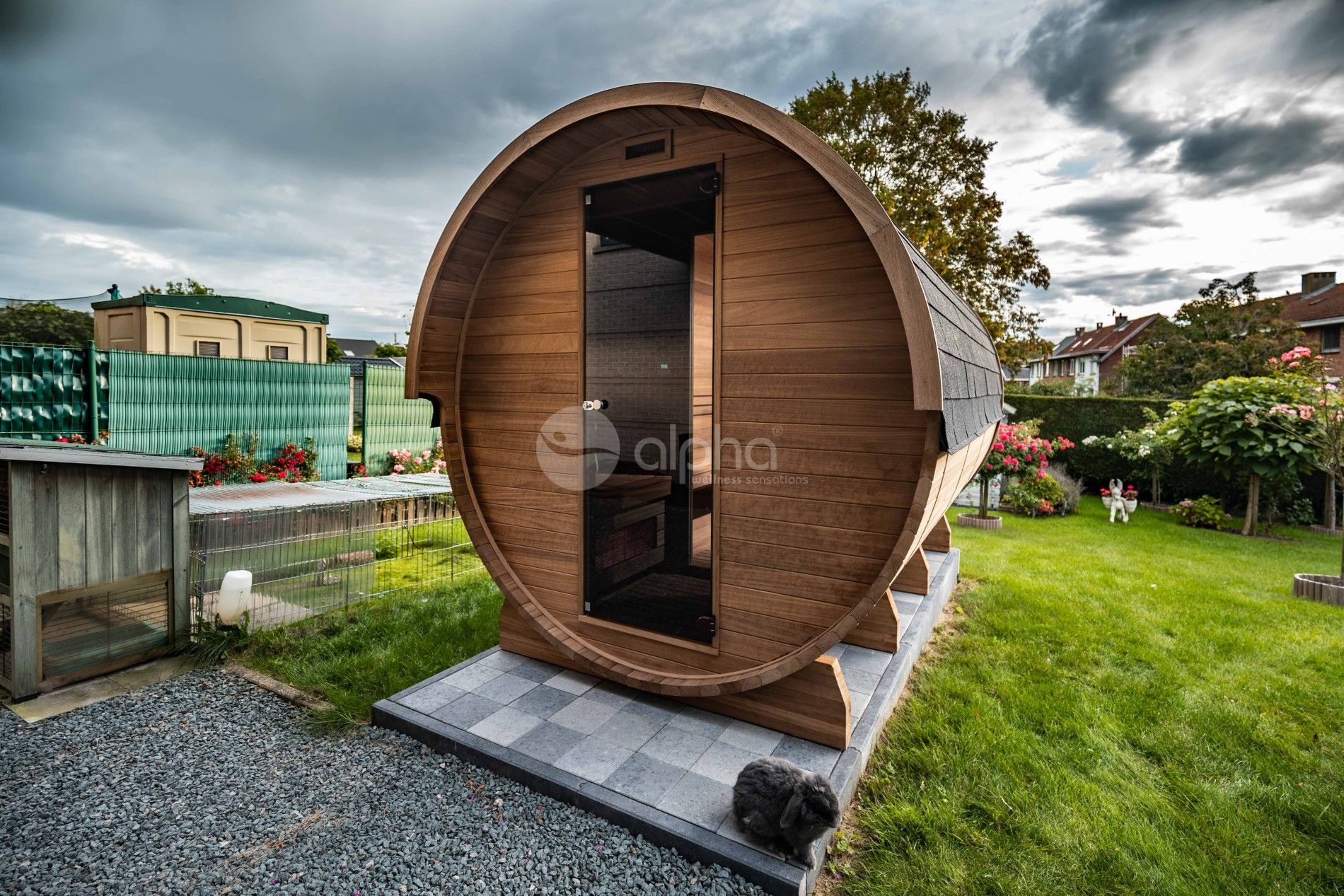 Un tonneau en bois est posé au milieu d'un champ herbeux.