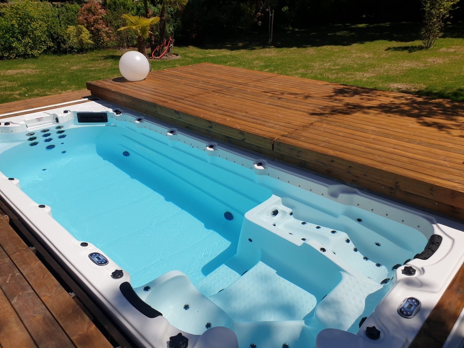 Une grande piscine est située sur une terrasse en bois.