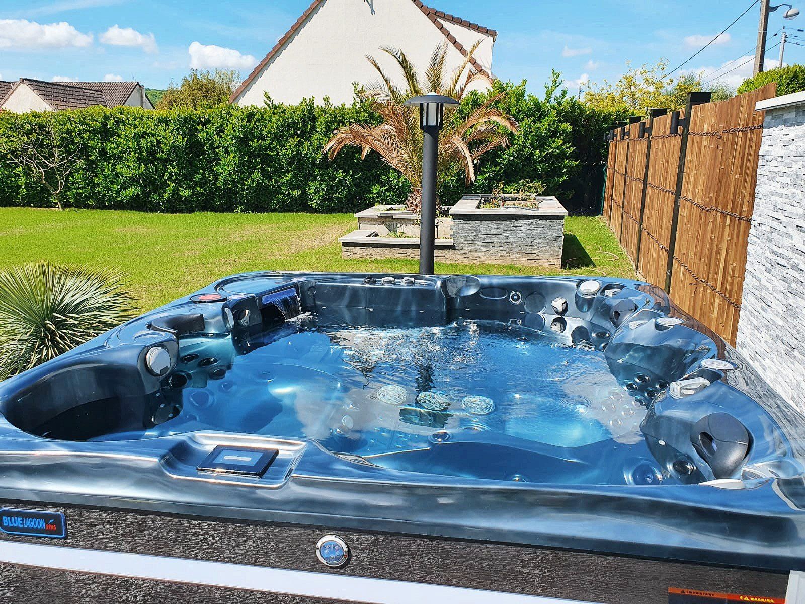 Un bain à remous est installé dans l'arrière-cour d'une maison.