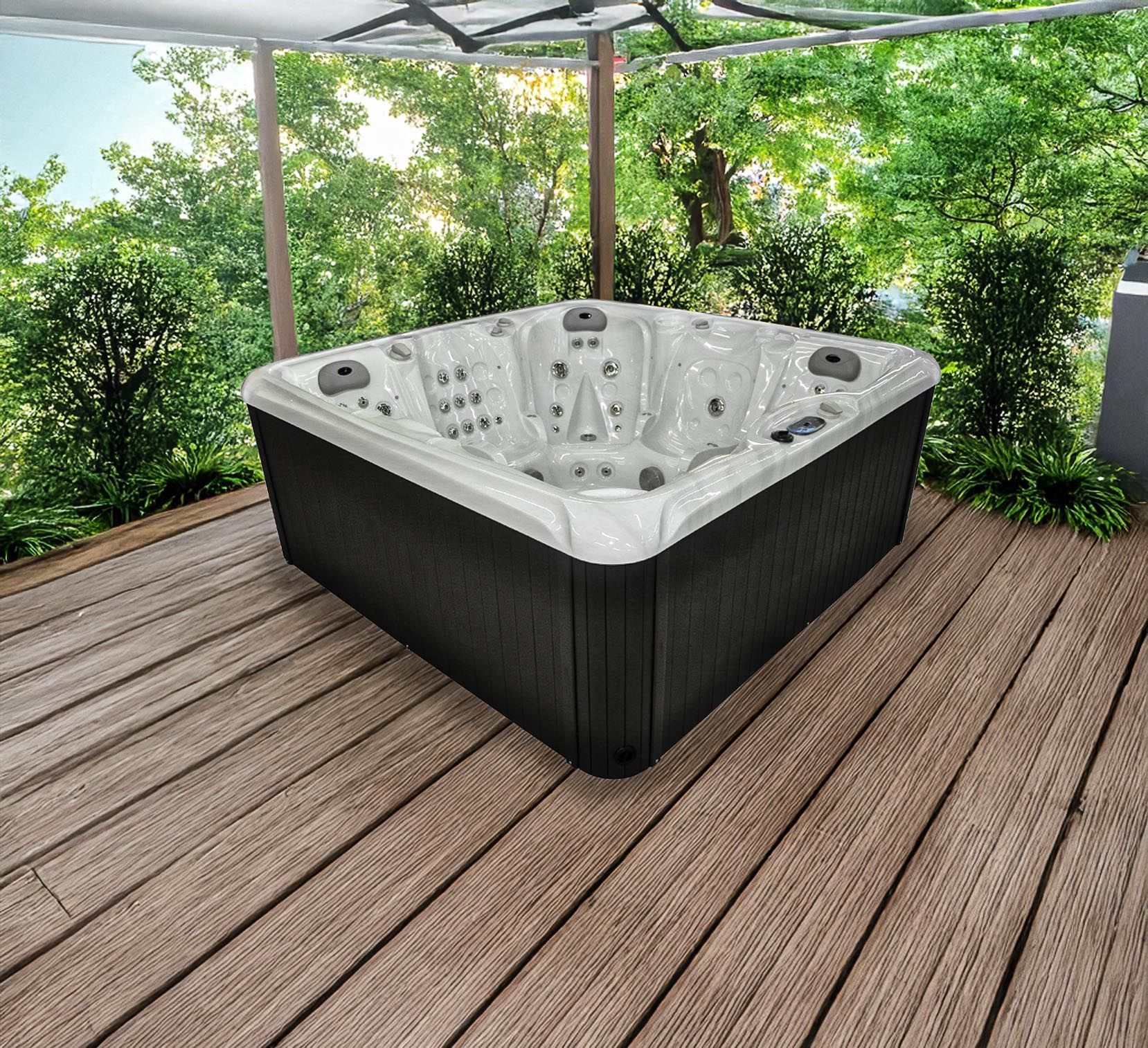 Un jacuzzi est installé sur une terrasse en bois surmontée d'un auvent, entouré d'une végétation luxuriante. Son extérieur est noir et son intérieur blanc.