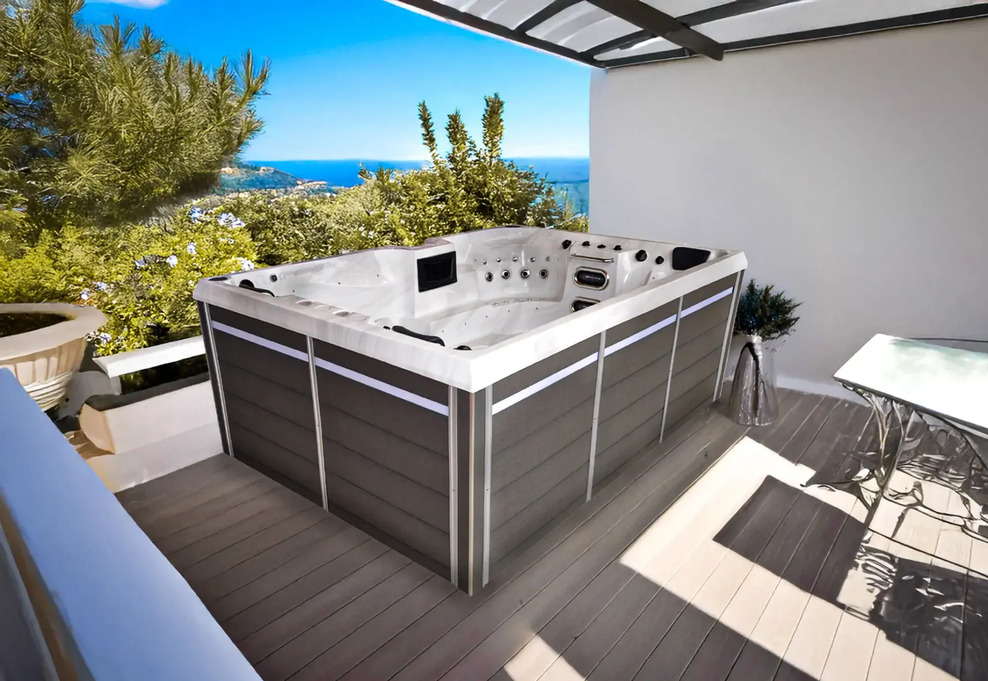 Un grand bain à remous est installé sur une terrasse surplombant l'océan
