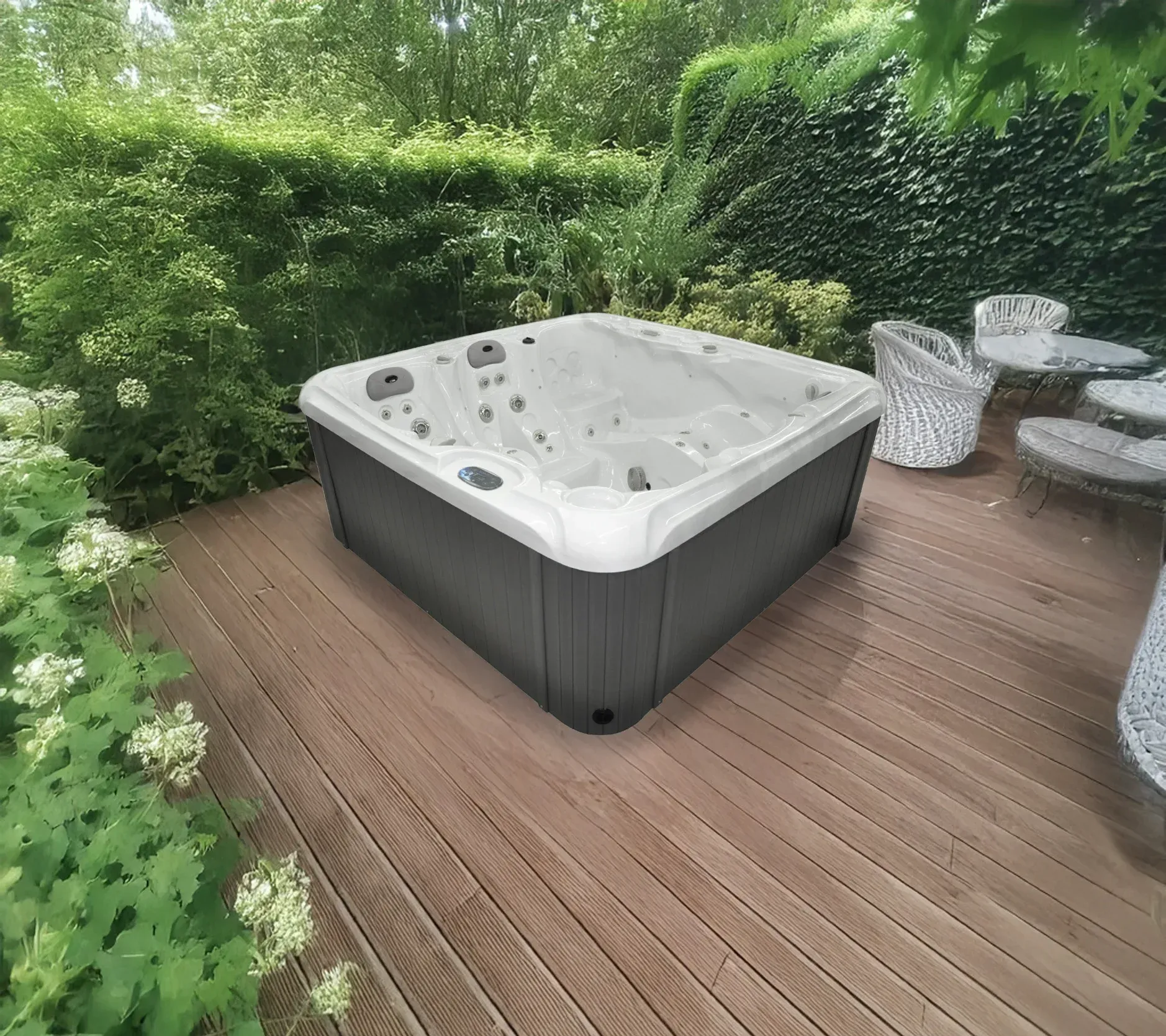 Un spa est installé sur une terrasse en bois dans un jardin à la végétation luxuriante.