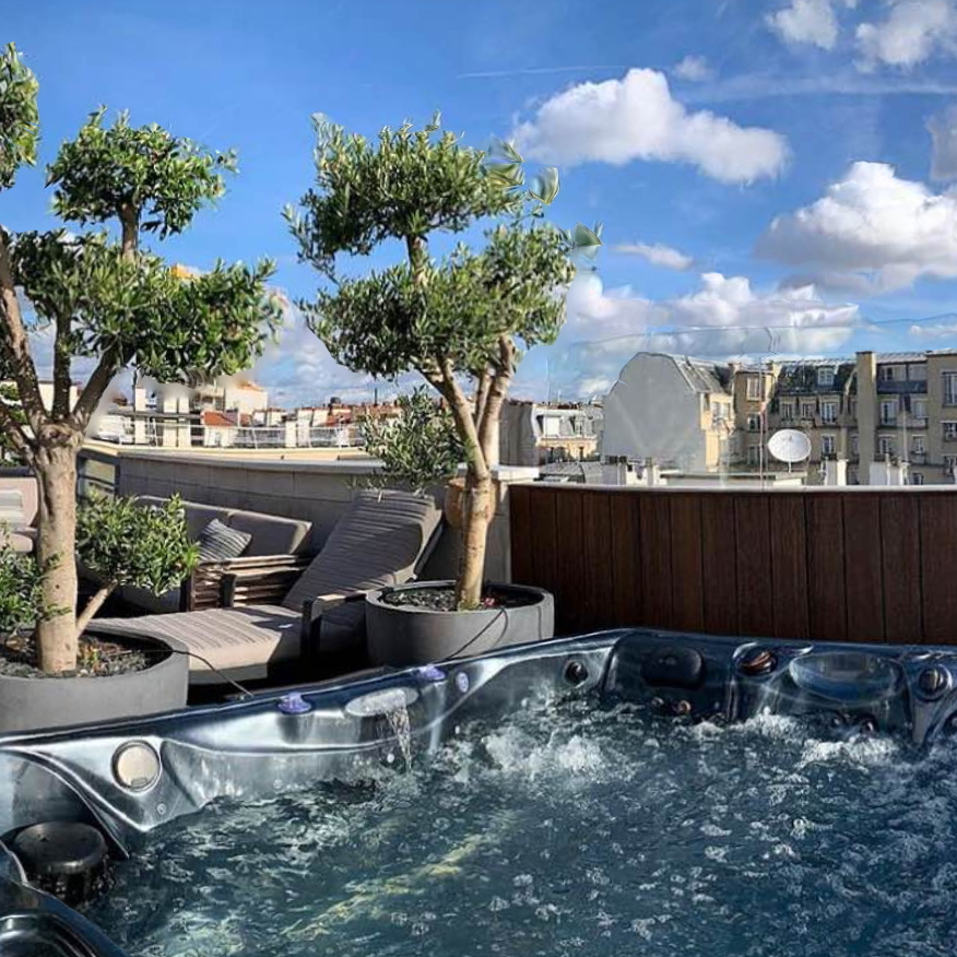 Il y a un jacuzzi sur le toit d'un immeuble avec des arbres en arrière-plan.